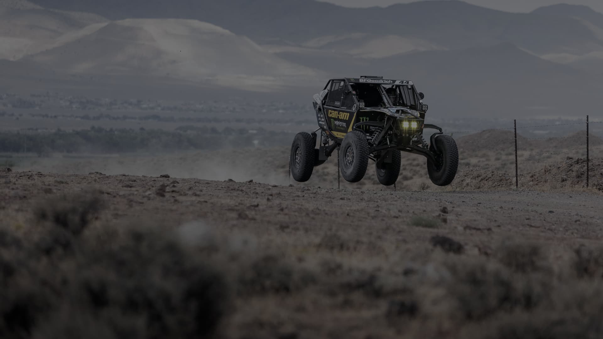 Багги Can-Am Maverick в прыжке на пустынной трассе